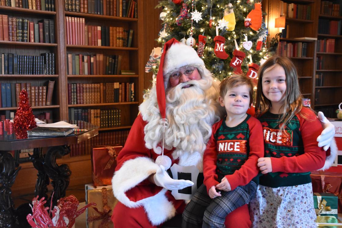 Photograph of two children visiting with Santa in the Cranbrook House Library.