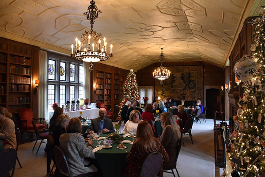Photograph of guests at a holiday tea in the Cranbrook House Library.