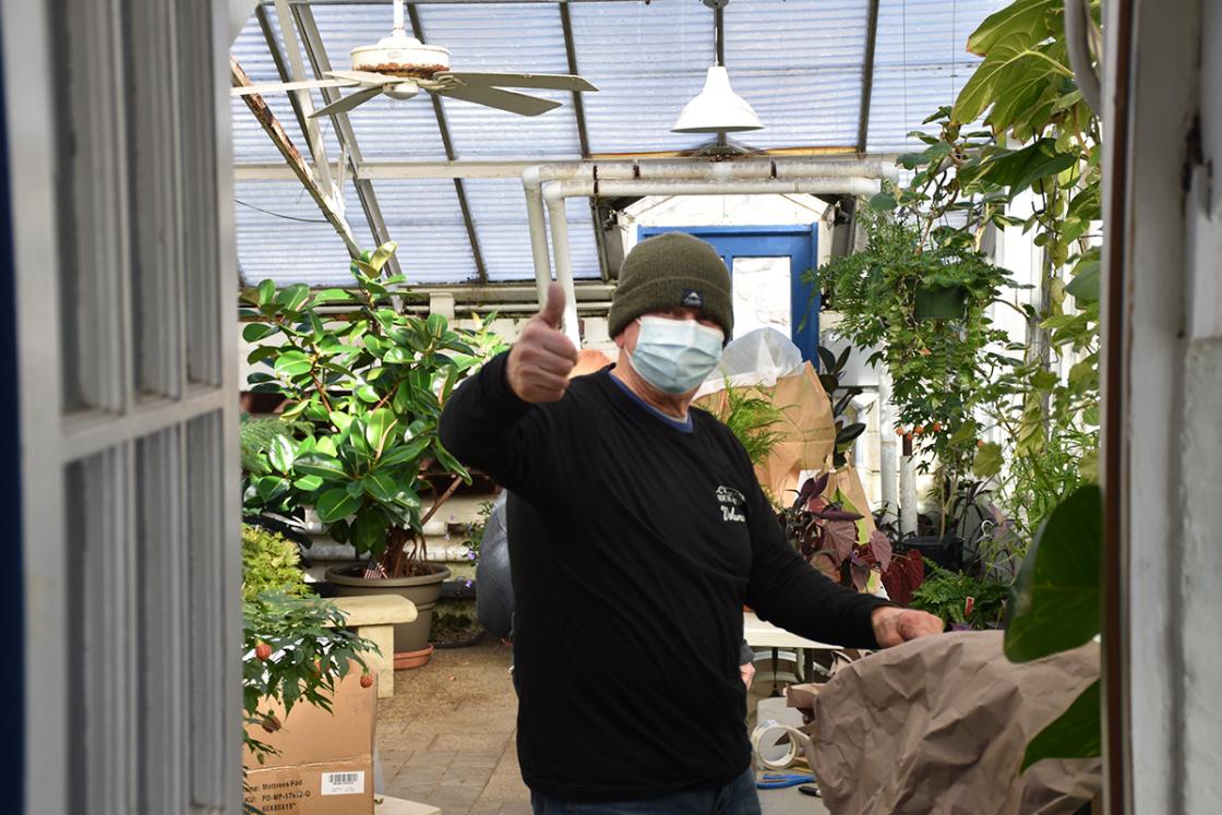 Photograph of a volunteer giving a thumbs up in the Conservatory Greenhouse