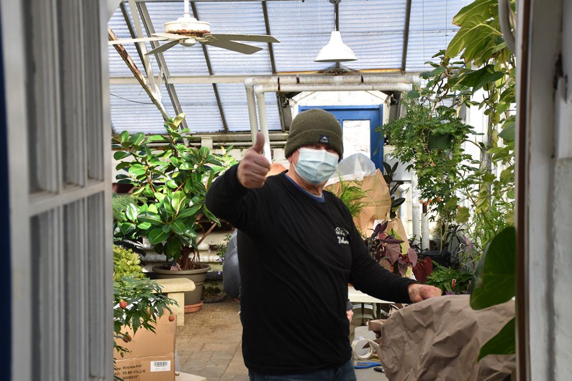 Photograph of a volunteer giving a thumbs up in the Conservatory Greenhouse