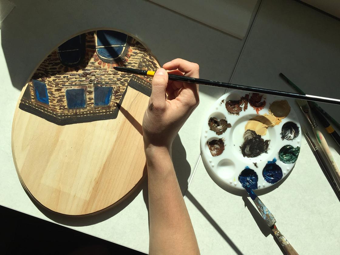 Photograph of a student painting a cartouche in the Cranbrook Art Museum Art Lab, October 2018.