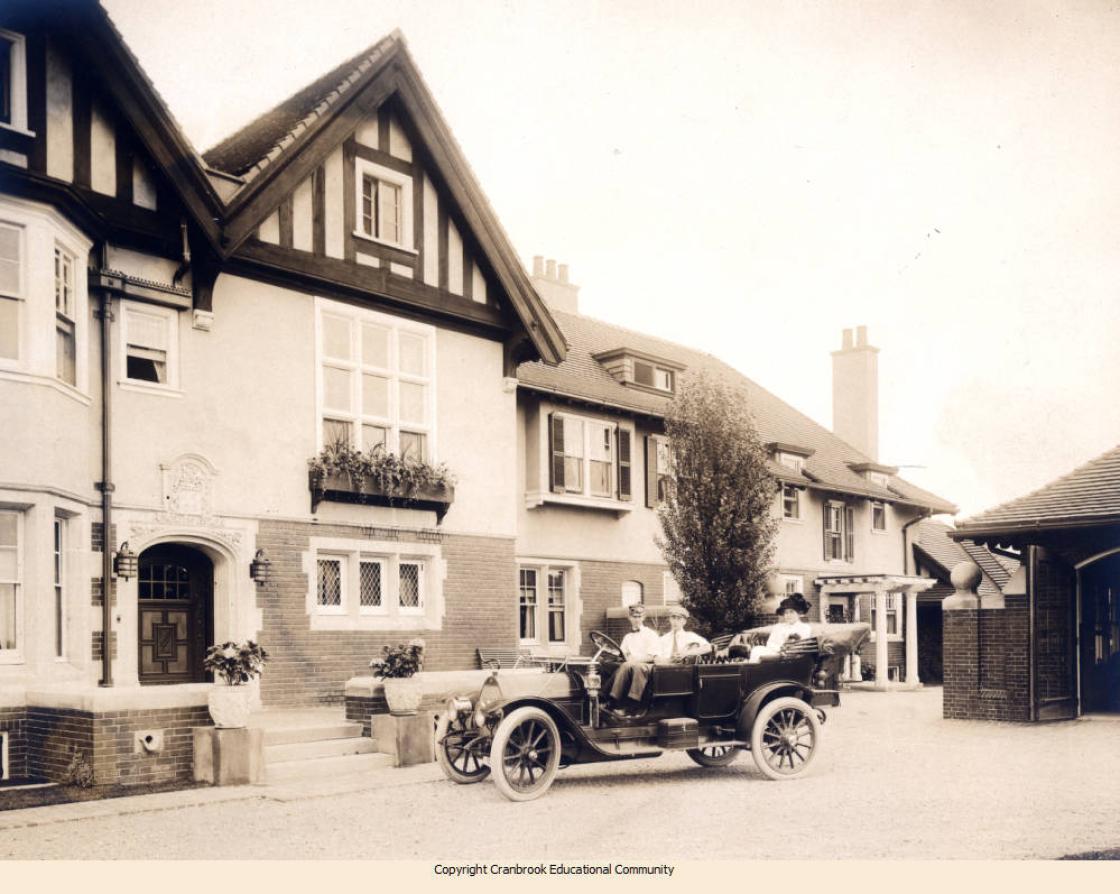 Photo of the Booth's 1910 Chalmers 40 in front of Cranbrook House.  Seated in front are Parks Walters (the family's first chauffeur) and Warren Booth, with Grace Booth in the back seat.