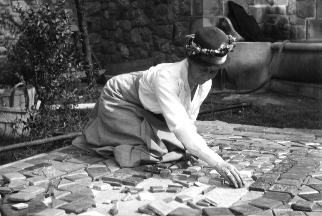 Photograph of Mary Chase Perry Stratton laying Pewabic tiles at Cranbrook's Rainbow Fountain.